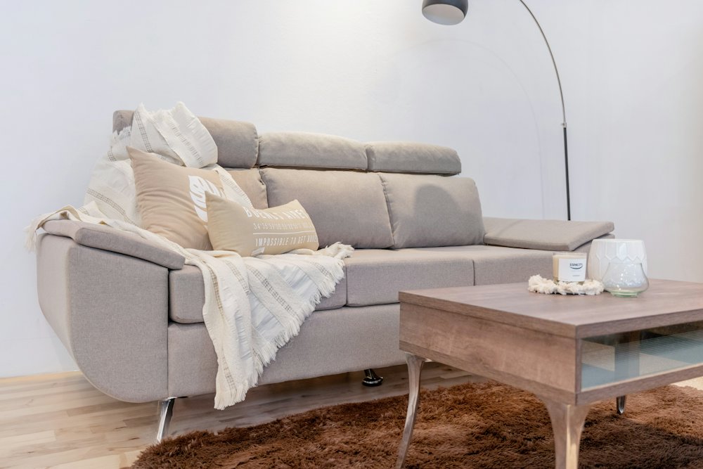 Canapé en tissu clair et tapis dans un salon lumineux